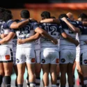 A group of rugby league players observe a minutes silence