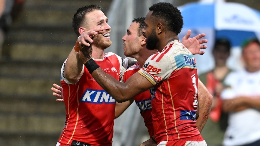 Three Dolphins NRL players embrace as they celebrate a try.