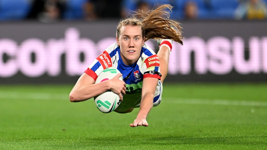 A Newcastle Knights NRLW player dives to score a try.