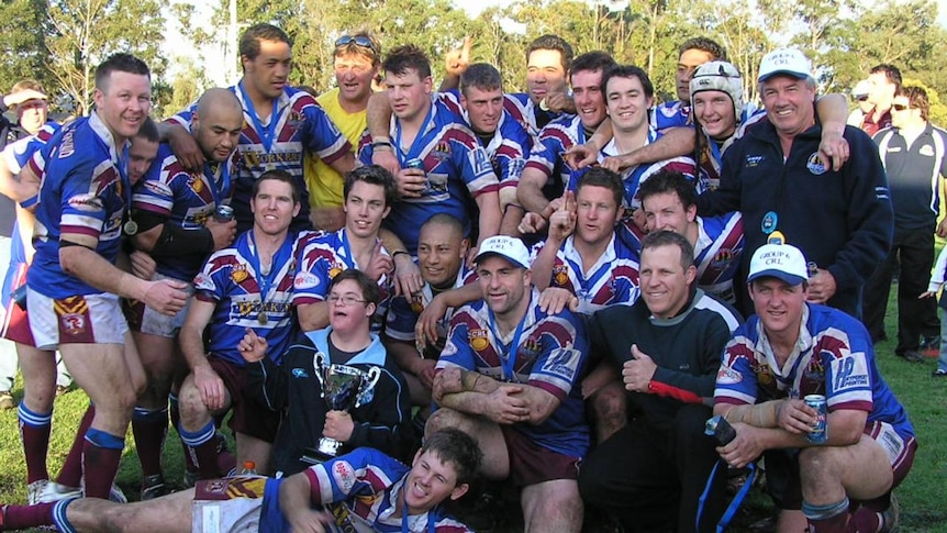 A group of men celebrate winning a grand final