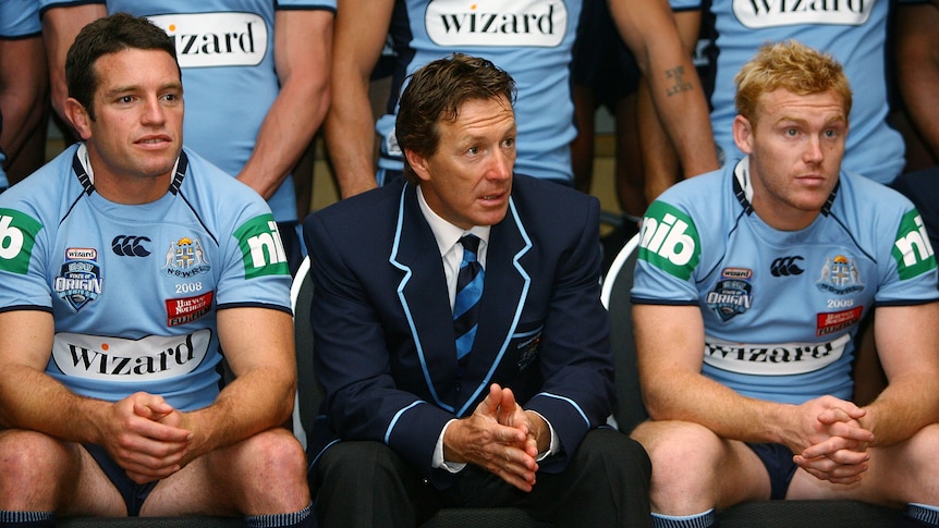 A rugby league coach smiles during a team photo