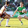 A Canberra Raiders NRL player carrying the ball steps to try and change direction and evade a Broncos defender.