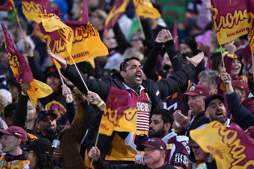 Brisbane Broncos fans at Canberra Stadium cheering and waving flags