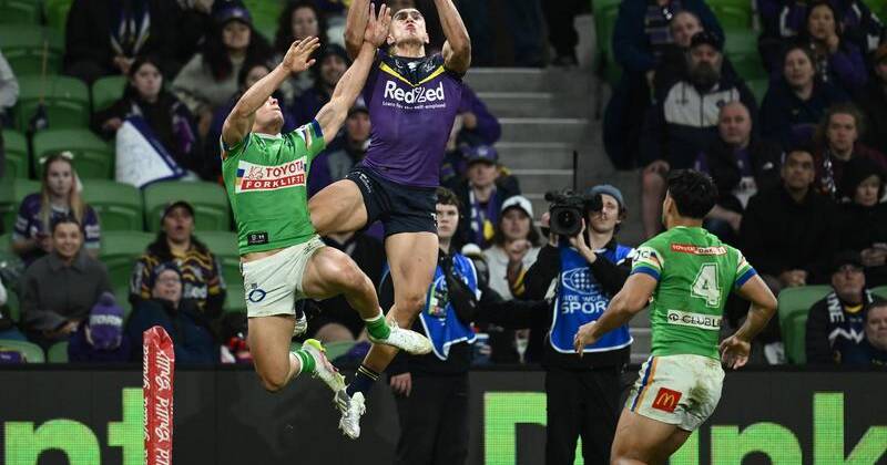 Will Warbrick climbs high to score one of his three tries to help the Storm overcome the Raiders. Photo: Joel Carrett/AAP PHOTOS
